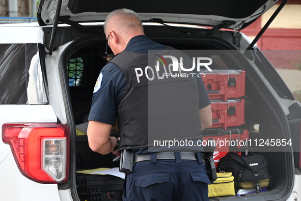 A police officer is on the scene of the crime. A 26-year-old male victim is injured in a shooting in Chicago, Illinois, United States, on Ma...