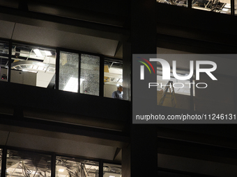 A worker is surveying the damage from inside 1001 Louisiana St. after the storm in Houston, Texas, on May 16, 2024. (