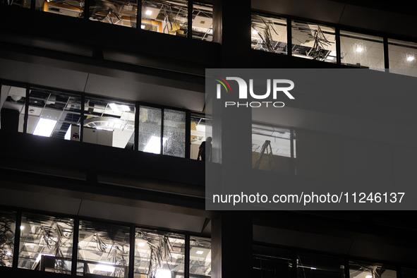 A worker is surveying the damage from inside 1001 Louisiana St. after the storm in Houston, Texas, on May 16, 2024. 