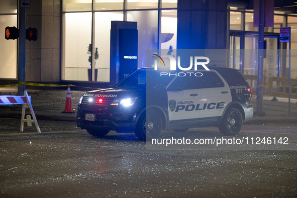 A police car is being seen on a downtown road covered in shattered glass after the storm in City, Country, on May 16, 2024. 