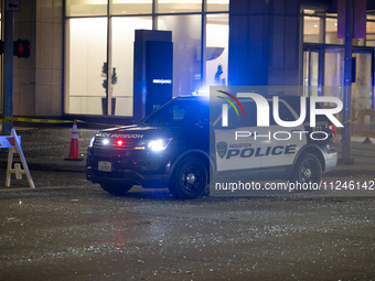 A police car is being seen on a downtown road covered in shattered glass after the storm in City, Country, on May 16, 2024. (