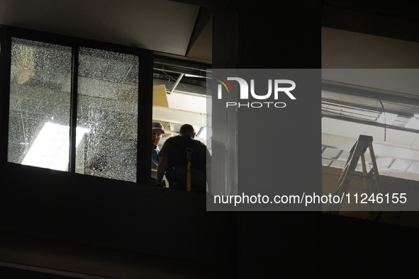 Workers are surveying the damage from inside 1001 Louisiana St. after the storm in Houston, Texas, on May 16, 2024. 