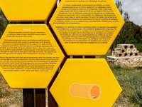 A sign is explaining what a ''tziverti'' is (a traditional domestic beehive), with a tziverti installment in the background, in Nicosia, Cyp...