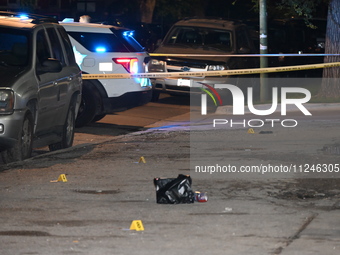 Evidence markers are being placed at the crime scene. Three people are being shot, and one person is in critical condition in Chicago, Illin...