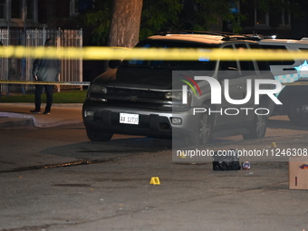 Evidence markers are at the crime scene. Three people are shot, and one person is in critical condition in Chicago, Illinois, United States,...