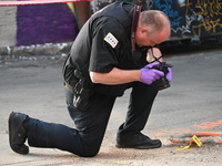 A police officer is taking a photograph of a shell casing at the crime scene. A 31-year-old male is in critical condition after attempting t...