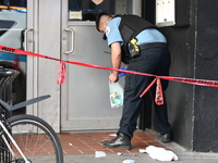 A police officer is collecting evidence at the crime scene. A 31-year-old male is in critical condition after attempting to intervene and st...