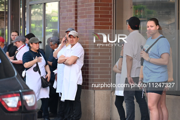 Workers of Eataly are gathering outside, wondering what is happening. There is a large police presence after an assault at Eataly Italian Re...