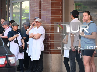 Workers of Eataly are gathering outside, wondering what is happening. There is a large police presence after an assault at Eataly Italian Re...