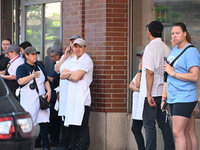 Workers of Eataly are gathering outside, wondering what is happening. There is a large police presence after an assault at Eataly Italian Re...