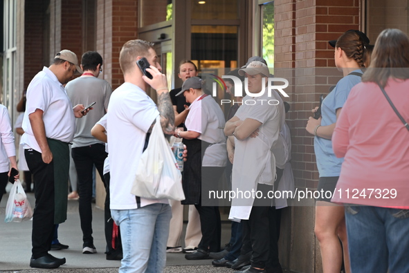 Workers of Eataly are gathering outside, wondering what is happening. There is a large police presence after an assault at Eataly Italian Re...