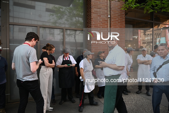 Workers of Eataly are gathering outside, wondering what is happening. There is a large police presence after an assault at Eataly Italian Re...