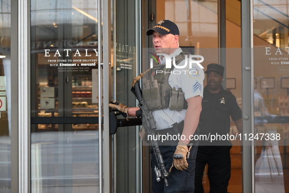 A police officer is exiting Eataly with a weapon. There is a large police presence after an assault at Eataly Italian Restaurant in Chicago,...