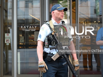 A police officer is exiting Eataly with a weapon. There is a large police presence after an assault at Eataly Italian Restaurant in Chicago,...