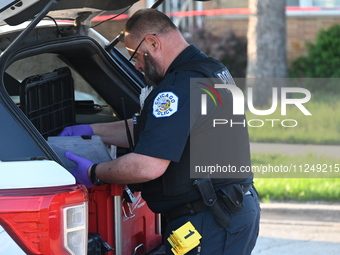 A police officer is placing evidence markers and collecting equipment at the residence where the homicide is occurring. A 54-year-old male v...