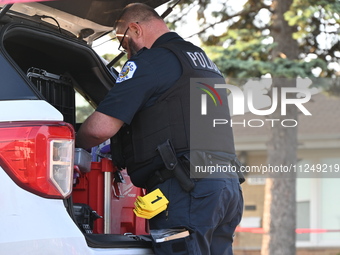 A police officer is placing evidence markers and collecting equipment at the residence where the homicide is occurring. A 54-year-old male v...