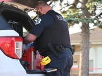 A police officer is placing evidence markers and collecting equipment at the residence where the homicide is occurring. A 54-year-old male v...