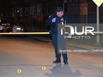 Evidence markers are being placed on the ground where shell casings are being discovered at the crime scene. Three people are being shot in...