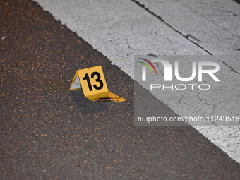 An evidence marker is lying on the ground where shell casings are being discovered at the crime scene. Three people are being shot in Chicag...