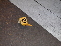 An evidence marker is lying on the ground where shell casings are being discovered at the crime scene. Three people are being shot in Chicag...