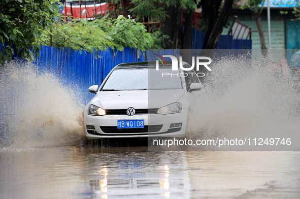 People are driving through a flooded urban road in the rain on Xinxing Road in Rongan county, Liuzhou city, South China's Guangxi Zhuang Aut...