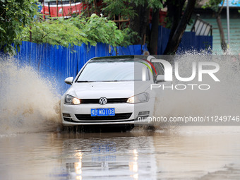 People are driving through a flooded urban road in the rain on Xinxing Road in Rongan county, Liuzhou city, South China's Guangxi Zhuang Aut...