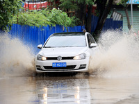 People are driving through a flooded urban road in the rain on Xinxing Road in Rongan county, Liuzhou city, South China's Guangxi Zhuang Aut...