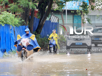 People are driving through a flooded urban road in the rain on Xinxing Road in Rongan county, Liuzhou city, South China's Guangxi Zhuang Aut...