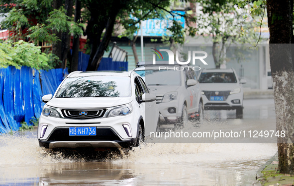 People are driving through a flooded urban road in the rain on Xinxing Road in Rongan county, Liuzhou city, South China's Guangxi Zhuang Aut...