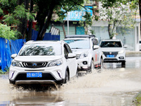 People are driving through a flooded urban road in the rain on Xinxing Road in Rongan county, Liuzhou city, South China's Guangxi Zhuang Aut...