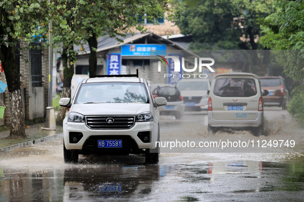 People are driving through a flooded urban road in the rain on Xinxing Road in Rongan county, Liuzhou city, South China's Guangxi Zhuang Aut...