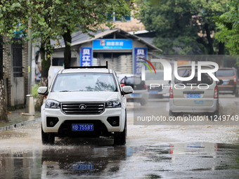 People are driving through a flooded urban road in the rain on Xinxing Road in Rongan county, Liuzhou city, South China's Guangxi Zhuang Aut...