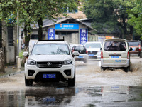 People are driving through a flooded urban road in the rain on Xinxing Road in Rongan county, Liuzhou city, South China's Guangxi Zhuang Aut...