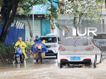 People are driving through a flooded urban road in the rain on Xinxing Road in Rongan county, Liuzhou city, South China's Guangxi Zhuang Aut...