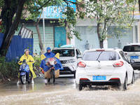 People are driving through a flooded urban road in the rain on Xinxing Road in Rongan county, Liuzhou city, South China's Guangxi Zhuang Aut...