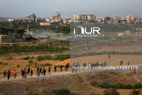 Palestinians are walking towards trucks transporting aid that is being delivered into Gaza through a U.S.-built pier, amid the ongoing confl...