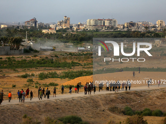 Palestinians are walking towards trucks transporting aid that is being delivered into Gaza through a U.S.-built pier, amid the ongoing confl...