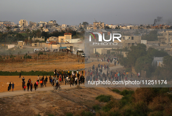 Palestinians are walking towards trucks transporting aid that is being delivered into Gaza through a U.S.-built pier, amid the ongoing confl...