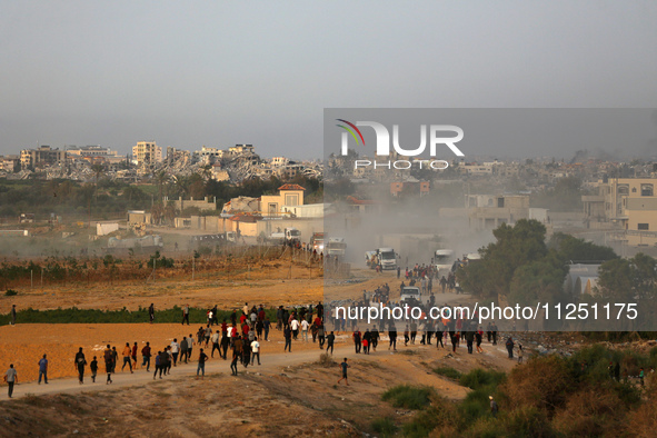 Palestinians are walking towards trucks transporting aid that is being delivered into Gaza through a U.S.-built pier, amid the ongoing confl...