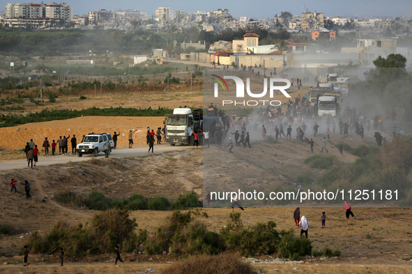 Palestinians are grabbing aid from a truck that is being delivered into Gaza through a U.S.-built pier, amid the ongoing conflict between Is...