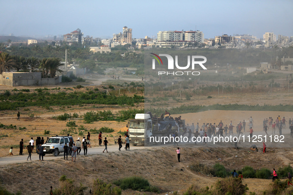 Palestinians are grabbing aid from a truck that is being delivered into Gaza through a U.S.-built pier, amid the ongoing conflict between Is...