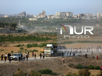 Palestinians are grabbing aid from a truck that is being delivered into Gaza through a U.S.-built pier, amid the ongoing conflict between Is...