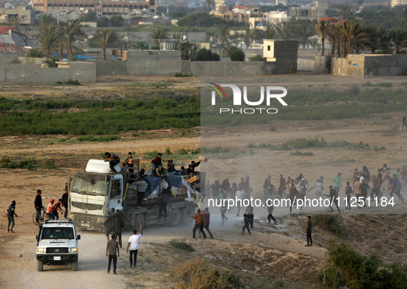 Palestinians are grabbing aid from a truck that is being delivered into Gaza through a U.S.-built pier, amid the ongoing conflict between Is...