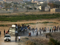 Palestinians are grabbing aid from a truck that is being delivered into Gaza through a U.S.-built pier, amid the ongoing conflict between Is...