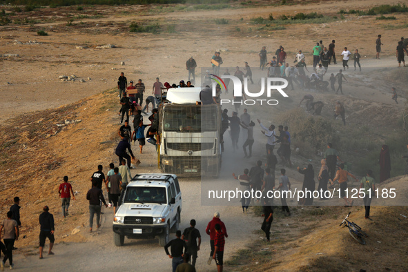 Palestinians are grabbing aid from a truck that is being delivered into Gaza through a U.S.-built pier, amid the ongoing conflict between Is...