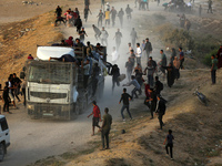 Palestinians are grabbing aid from a truck that is being delivered into Gaza through a U.S.-built pier, amid the ongoing conflict between Is...