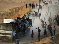 Palestinians are grabbing aid from a truck that is being delivered into Gaza through a U.S.-built pier, amid the ongoing conflict between Is...