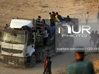 Palestinians are grabbing aid from a truck that is being delivered into Gaza through a U.S.-built pier, amid the ongoing conflict between Is...