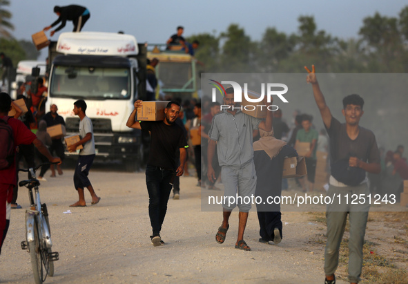 Palestinians are carrying boxes of aid that are being delivered into Gaza through a U.S.-built pier, amid the ongoing conflict between Israe...