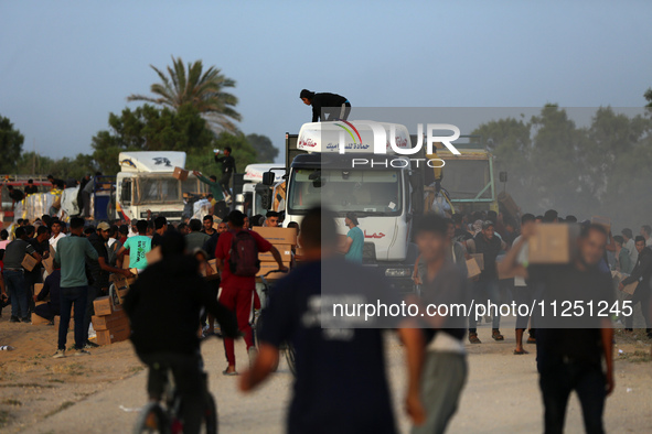 Palestinians are climbing onto trucks to grab aid that is being delivered into Gaza through a U.S.-built pier, amid the ongoing conflict bet...